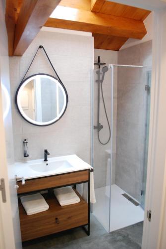 y baño con lavabo y ducha con espejo. en ALTAR SUITES Caño Badillo en León
