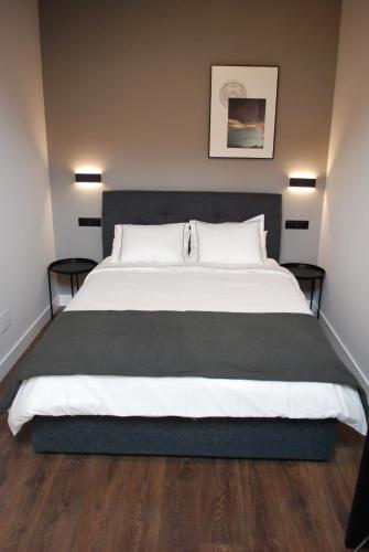 a bedroom with a large bed with two tables at Altar Suites Caño Badillo by gaiarooms in León