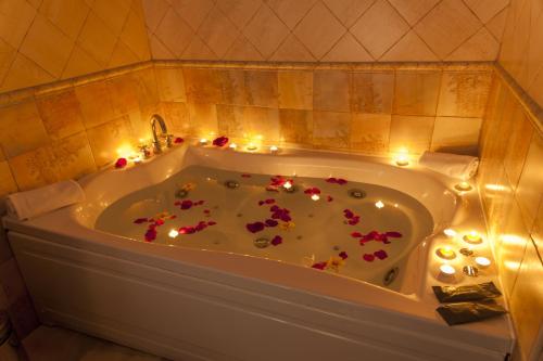 a bath tub with candles and flowers in it at Hotel Comendador in Carranque