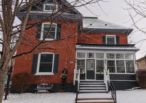 a red brick house with a front door and stairs at Colborne Bed and Breakfast in Goderich