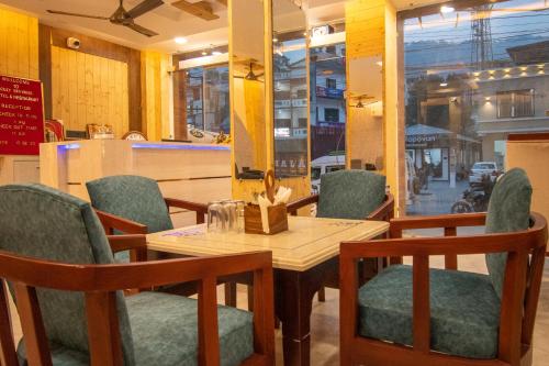 a dining room with a table and chairs and a window at Holy Shivana Boutique Hotel Rishikesh in Rishīkesh
