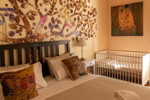 ein Schlafzimmer mit einem Kinderbett und einem Baumbild in der Unterkunft Central City Genova in Genua