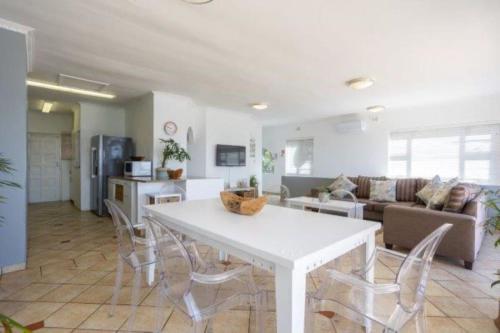 a kitchen and living room with a white table and chairs at The Villa Umdloti in Umdloti