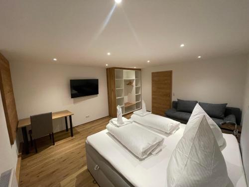1 dormitorio con cama blanca y sofá en Landgasthaus zum Kreuz GbR, en Isny im Allgäu