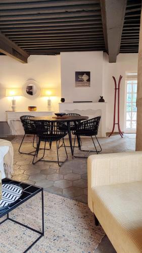 un salon avec une table et des chaises dans l'établissement Uzès, au cœur du centre médiéval Le Logis du Consul un bien d'exception du XVIème siècle, à Uzès