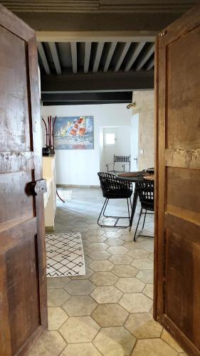 une porte ouverte menant à une chambre avec une table et des chaises dans l'établissement Uzès, au cœur du centre médiéval Le Logis du Consul un bien d'exception du XVIème siècle, à Uzès