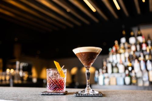 a martini and a drink sitting on a bar at Hotel Krone - Aktiv & Erholt in Churwalden