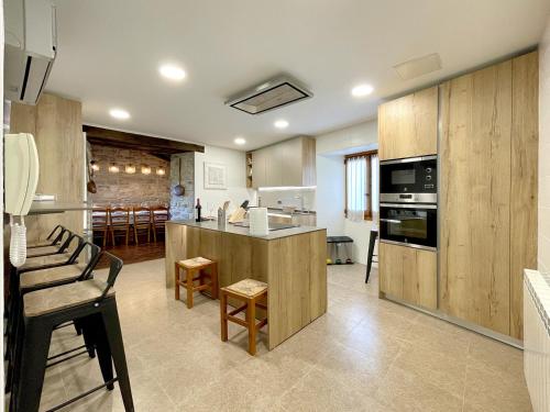 a large kitchen with wooden cabinets and a counter top at CASA RURAL ERVITENA in Oteiza