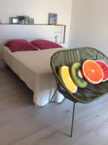 a bowl of fruit on a chair next to a bed at Centre historique bastia in Bastia