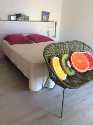 - une corbeille de fruits sur une chaise à côté du lit dans l'établissement Centre historique bastia, à Bastia