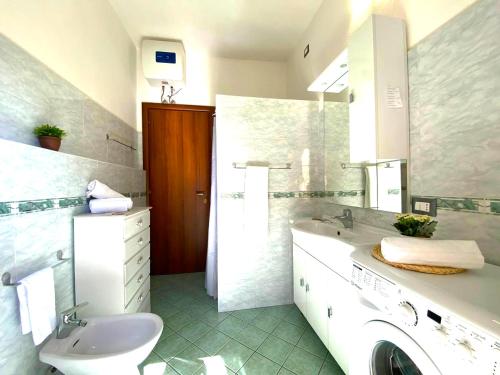 a bathroom with a sink and a washing machine at Domu Irene - Triei in Triei