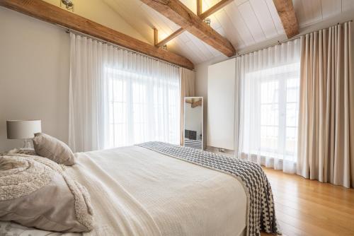 a bedroom with a large bed and two windows at Uus 30 Apartments in Tallinn