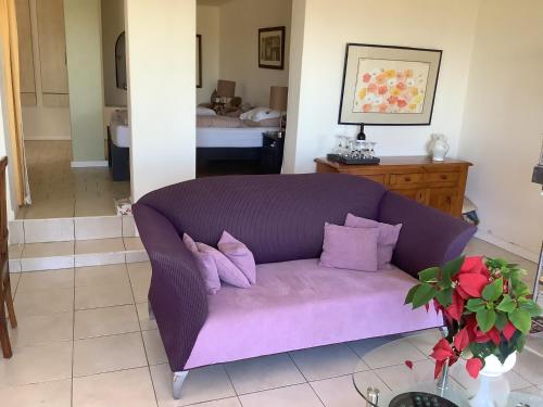 a purple couch sitting in a living room at Cozy Garden apartment with amazing view in Cape Town