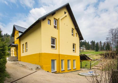 a yellow house with a black roof at Chata U Skota in Janov nad Nisou