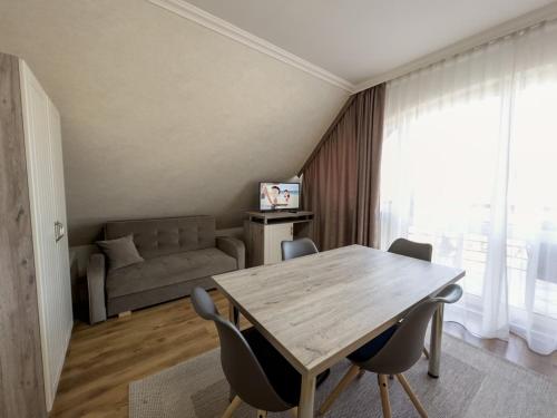 a living room with a wooden table and chairs at Járja Panzió in Hajdúszoboszló