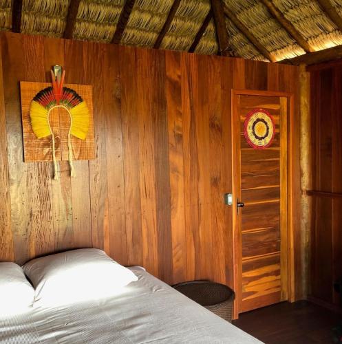 a bedroom with a bed and a wooden wall at Ventos do Delta Kite Chalés in Tutóia