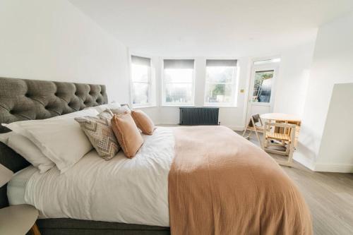 a bedroom with a large bed with pillows on it at New - Bright - Fresh - with Parking in Bath