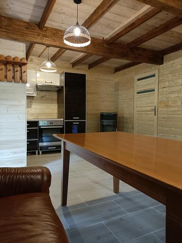 a large wooden table in a kitchen with a couch at Dom Sosnowy in Szczytno