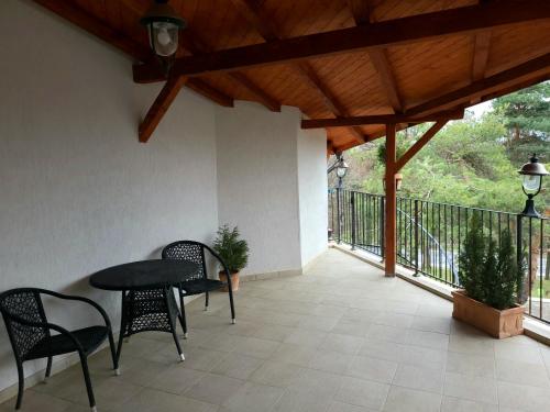 a patio with a table and chairs and a wooden ceiling at Cabana Stejarul in Botoşani