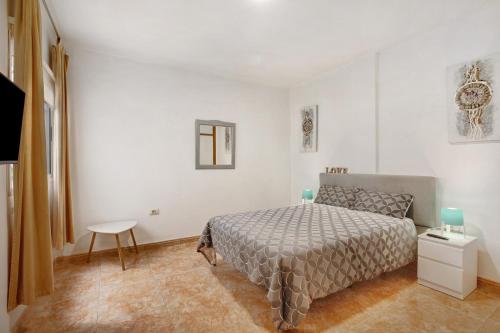 a white bedroom with a bed and a table at 3 bedroom apartment near Sta Cruz in Santa Cruz de Tenerife