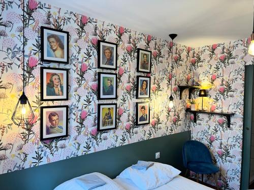a bedroom with a wall with pictures on it at La maison des amis in Nuits