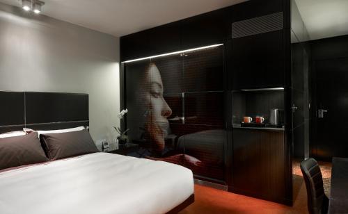 a bedroom with a bed and a picture of a woman at Park Plaza London Westminster Bridge in London