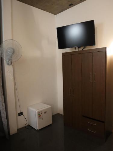 a room with a fan and a television on a cabinet at Hostal Litoral in Iquique