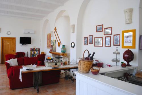 a living room with a table and a red couch at Hotel Giardino Giamperduto in Bernalda