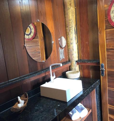a bathroom with a sink and a mirror at Ventos do Delta Kite Chalés in Tutóia