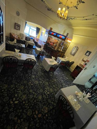 a restaurant with tables and chairs in a room at Nevele in Blackpool