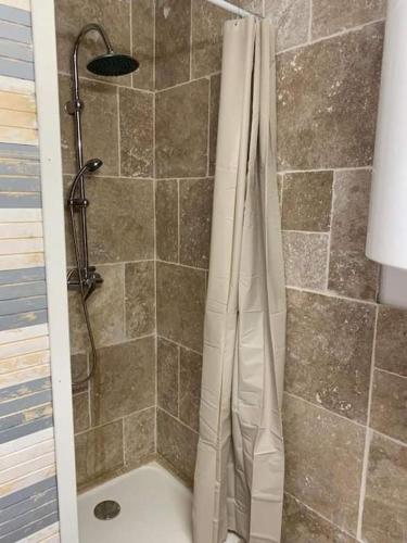 une douche avec un rideau de douche dans une salle de bain dans l'établissement Patio avec cour et place de parking en bord de mer, à Port-la-Nouvelle