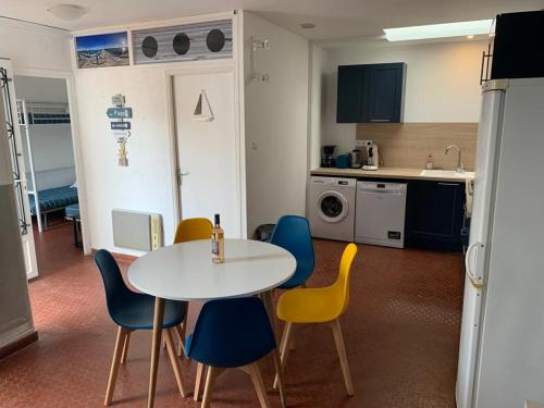 - une cuisine avec une table et des chaises dans la chambre dans l'établissement Patio avec cour et place de parking en bord de mer, à Port-la-Nouvelle