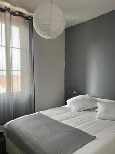 une chambre avec un grand lit avec une grande fenêtre dans l'établissement L’olivier, à Toulon