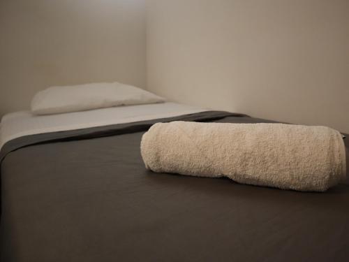 a bed with two towels on top of it at Hostal Litoral in Iquique