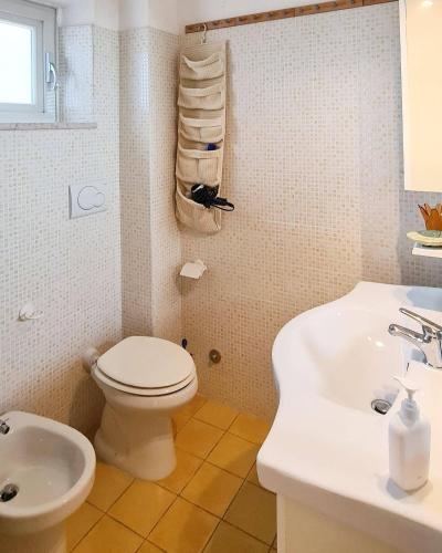 a bathroom with a toilet and a sink at Il Poggiolo di Levante - Piscina e Ombrellone spiaggia prima fila incluso in Marcelli