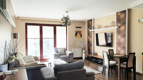 a living room with a couch and a table at Apartment Gdańsk Seaside & City Center in Gdańsk