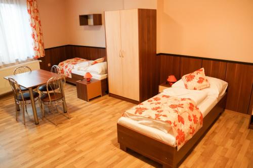 Turistická ubytovňa BUCK** في Tornaľa: غرفة نوم بسرير وطاولة وطاولة طعام