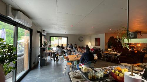 un grupo de personas sentadas en mesas en un restaurante en Le Volcan des Sens, chambres d'hotes de luxe et SPA, en Torsiac