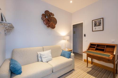 a living room with a couch and a piano at Auberge du Bon Laboureur Chenonceaux in Chenonceaux