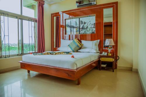 una camera con un grande letto con testiera in legno di Greenlight Hotel a Dar es Salaam