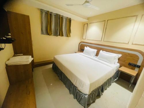 a bedroom with a large bed in a room at Hotel Nova Bopal in Bodakdev