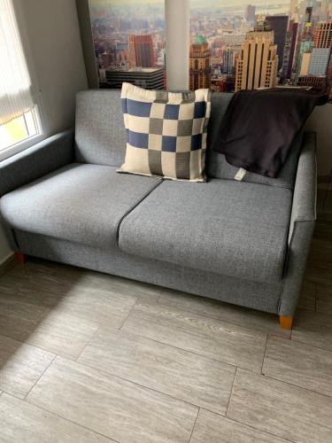 a gray couch with two pillows in a living room at Apartment near Arts & Science in Valencia