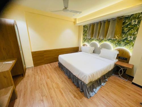 a bedroom with a bed and a window at Hotel Nova Bopal in Bodakdev