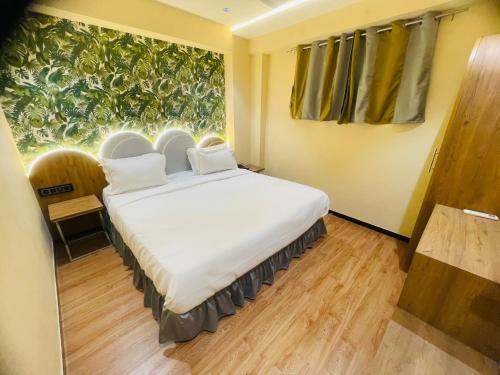 a bedroom with a large white bed in front of a window at Hotel Nova Bopal in Bodakdev