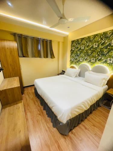 a bedroom with a large white bed in a room at Hotel Nova Bopal in Bodakdev