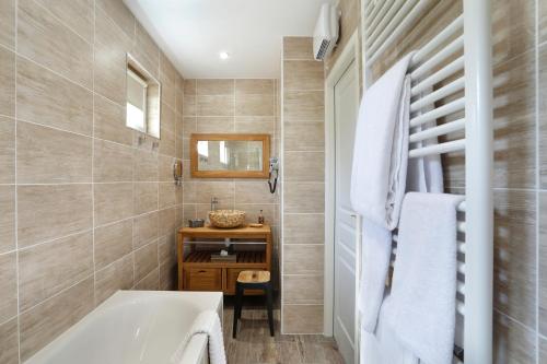 a bathroom with a tub and a sink at Auberge du Bon Laboureur Chenonceaux in Chenonceaux