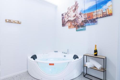 een bad in een badkamer met een schilderij aan de muur bij White Home Suite and Rooms in Rome