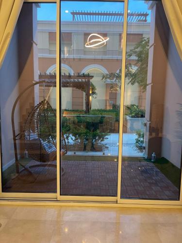 a large glass window with a reflection of a swing at Luxury Apartment by the Sea with Amazing Amenities at Pearl Qatar in Doha