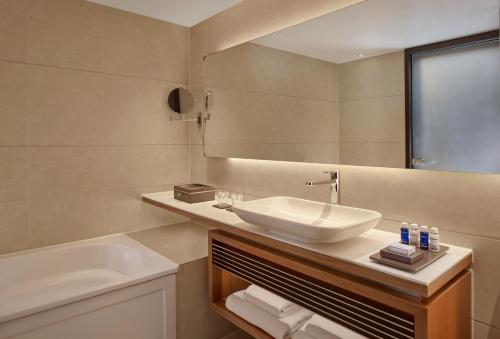 a bathroom with a sink and a mirror and a tub at Park Plaza London Westminster Bridge in London