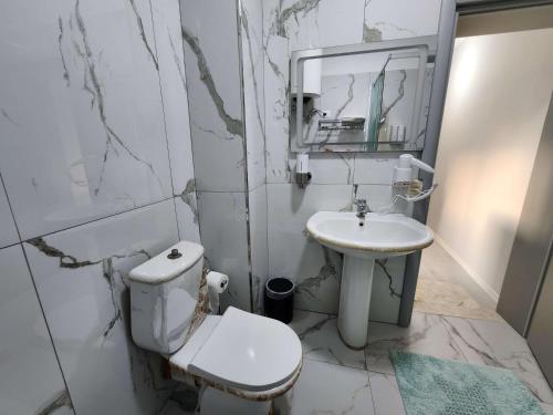 Un baño blanco con inodoro y lavabo. en Sweet Dreams Apartment Sari, en Tirana